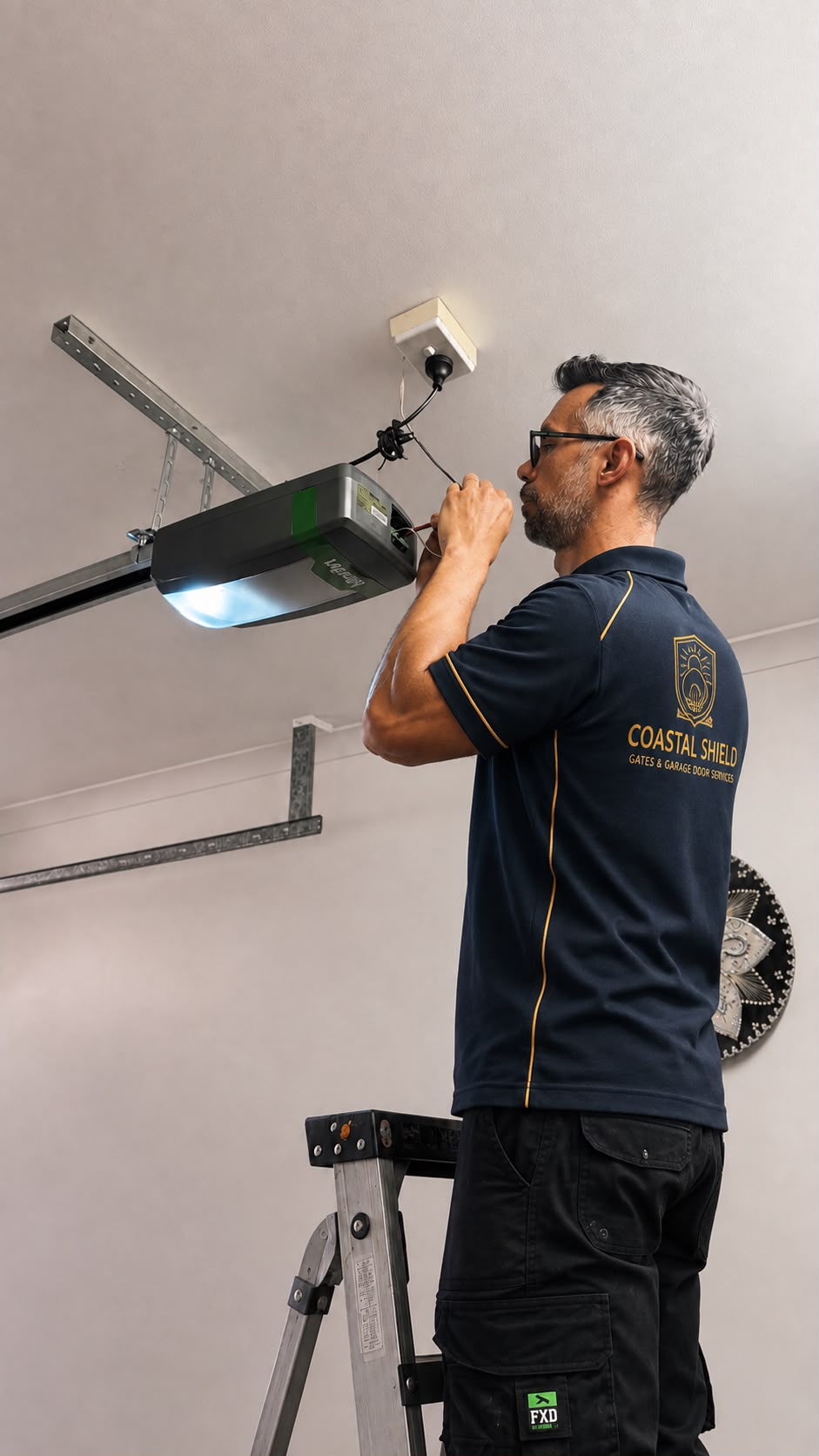 Coastal Shield technician installing a garage door motor